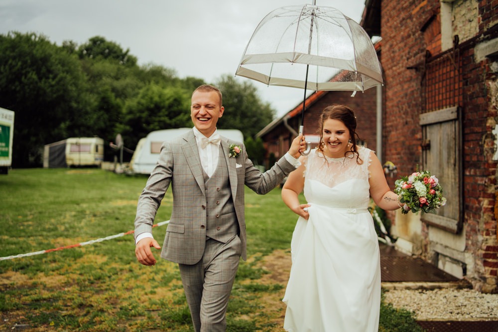 Titelbild einer Hochzeitsreportage. Brautpaar ist glücklich, trotz Regen am Hochzeitstag.